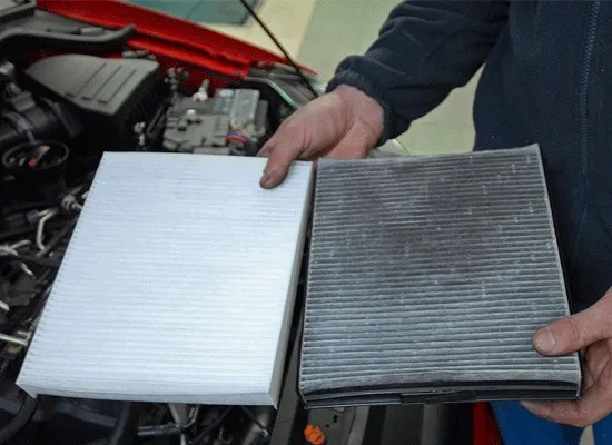 a person holding a clean and dirty air filter - plugged air filter cuts into fuel mileage
