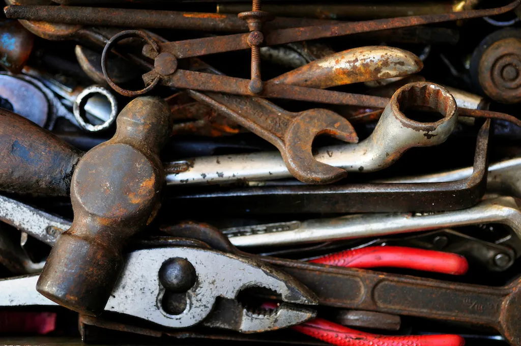 Old, dirty, rusty tools in a box.